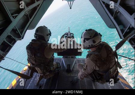 Des marins équipés d'une mitrailleuse de calibre 50 à l'arrière d'un MH-53E Sea Dragon. Banque D'Images