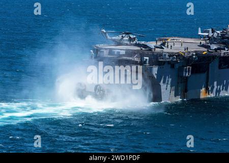 Un engin de débarquement, coussin d'air pénètre dans le pont du navire d'assaut amphibie USS Iwo Jima. Banque D'Images