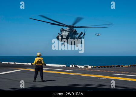 Aviation Boatswain's Mate signale à un CH-53E Super Stallion d'atterrir. Banque D'Images