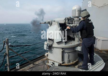 Gunner's Mate tire un Mark 38 Mod. Mitrailleuse 2 lors d'un exercice de tir réel à bord de l'USS Howard. Banque D'Images