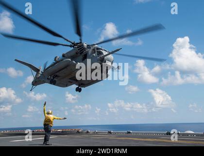 Airman signale au pilote d'un CH-53E Super Stallion que l'hélicoptère décolle de l'USS Bonhomme Richard. Banque D'Images