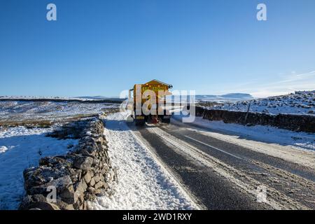 Un camion grincheux sillonnant les routes par une belle journée d'hiver dans le parc national des Yorkshire Dales en Angleterre, avec Pen-y-ghent en arrière-plan. Banque D'Images