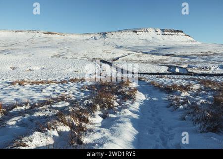 Un sentier de randonnée couvert de neige menant au sommet de Pen-y-ghent, une montagne dans le parc national des Yorkshire Dales. Prise par une belle journée d'hiver. Banque D'Images