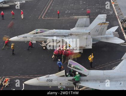 Les marins et les Marines américains effectuent une poussée d'avion à bord du porte-avions USS Nimitz. Banque D'Images