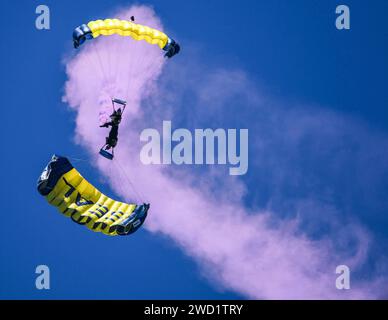 L'équipe de démonstration de parachutes de l'US Navy, les Leap Frogs, effectuent une manœuvre de traînée de fumée. Banque D'Images