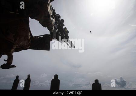 Un Marine des États-Unis tire un fusil automatique d'infanterie M27 lors d'un tir sur le pont à bord de l'USS Germantown. Banque D'Images