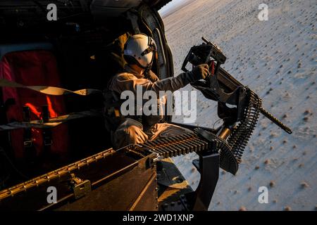 Naval Aircrewman manipule une mitrailleuse de calibre .50 lors d'une qualification initiale d'entraînement au tir aérien. Banque D'Images