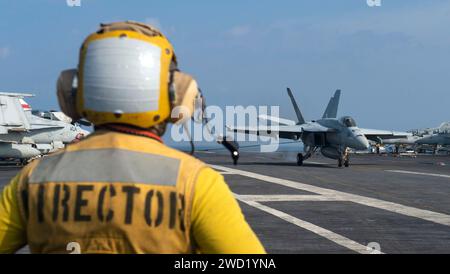 Aviation Boatswain's Mate regarde un F/A-18E Super Hornet faire un atterrissage arrêté sur l'USS Nimitz. Banque D'Images