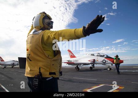 Aviation Boatswain's Mate signale un T-45C Goshawk sur le pont d'envol de l'USS Gerald R. Ford. Banque D'Images