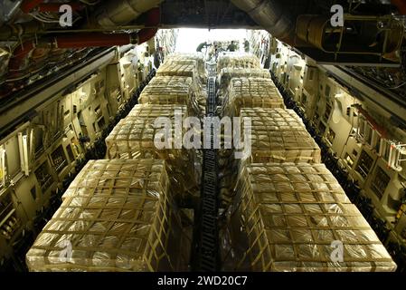 Les aviateurs chargent 90 000 livres d'eau et de repas prêts à manger sur un C-17 Globemaster III Banque D'Images