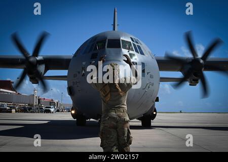 Un spécialiste de l'US Air Force marshale un C-130J Super Hercules. Banque D'Images