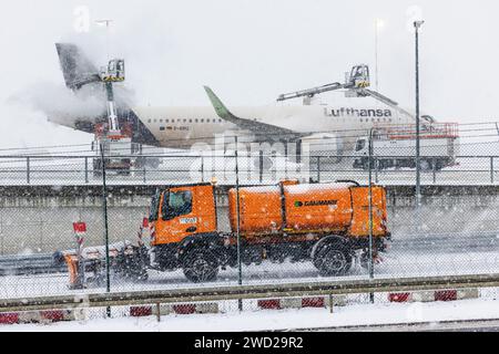 18 janvier 2024, Hesse, Francfort-sur-le-main : un Airbus A320neo de Lufthansa est en cours de dégivrage à l'aéroport de Francfort. Un véhicule de dégagement passe devant. De nombreux vols à l'aéroport de Francfort ont également été annulés jeudi en raison du risque persistant de conditions glaciales. Photo : Lando Hass/dpa Banque D'Images