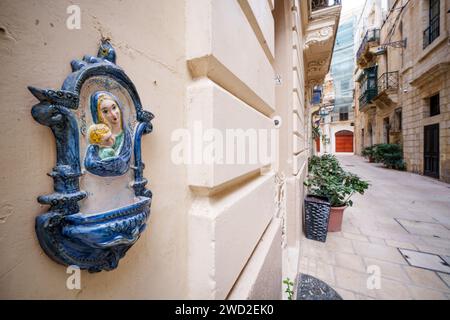 Figure religieuse de la Vierge Marie sur un mur de maison dans l'île de Malte. Banque D'Images