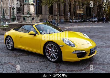 NANCY, FRANCE - 1 NOVEMBRE 2023 : il s'agit d'une voiture de sport allemande de luxe Porsche 911 Carrera Cabriolet en mouvement dans une rue de la ville. Banque D'Images