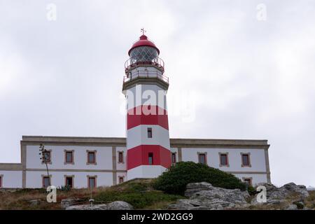 Le phare de Cabo Silleiro avec ses bandes rouges sur la montagne rocheuse guide les marins Banque D'Images