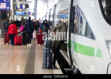 18 janvier 2024, Hesse, Francfort-sur-le-main : une femme monte à bord d'un train ICE avec ses bagages à la gare longue distance de l'aéroport de Francfort-sur-le-main. Photo : Lando Hass/dpa Banque D'Images