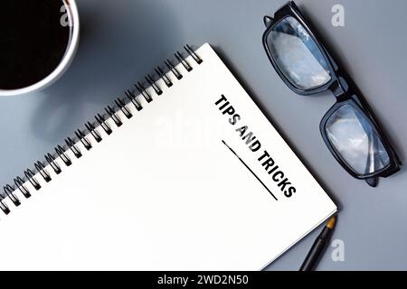 Trucs et astuces texte écrit sur bloc-notes avec stylo, café et lunettes de lecture. Banque D'Images