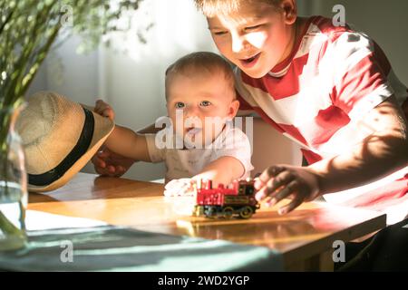 Frère porter chapeau bébé frère garçon. Famille avec enfants à la maison. Amour, confiance et tendresse Banque D'Images