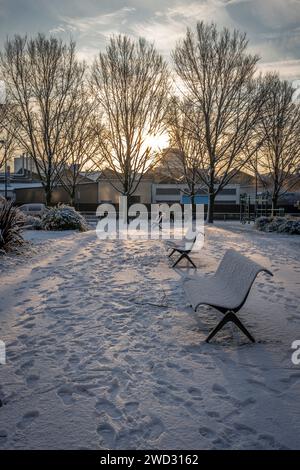 Gennevilliers, France - 12 18 2024 : éco-quartier. Vue de l'alignement des bancs le long d'un sentier sous la neige dans un parc Banque D'Images