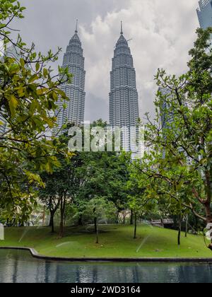 Parc et gratte-ciel de Kuala Lumpur en journée ensoleillée. Tours jumelles dans le centre de KL. Banque D'Images