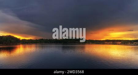 Coucher de soleil sur le lac. Beau panorama sur le lac avec en toile de fond le ciel de coucher de soleil. Banque D'Images