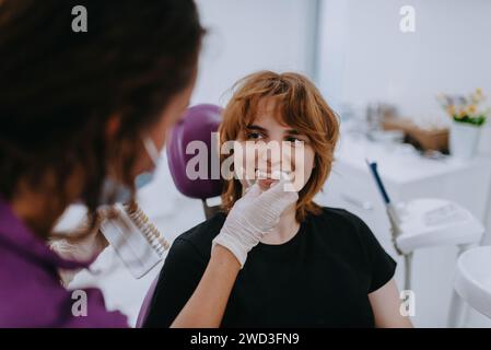 Un dentiste expérimente de nouvelles nuances de dents pour prothèses dans un cabinet dentaire, mettant en valeur la précision et l'innovation dans les soins dentaires Banque D'Images