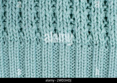 Texture et fond de pull turquoise tricoté en tissu synthétique. Banque D'Images