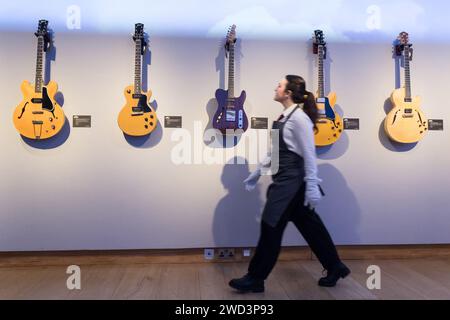 LONDRES, ROYAUME-UNI - 18 JANVIER 2023 : un membre du personnel passe devant des guitares exposées lors d'un photocall à la maison de vente aux enchères Christie's présentant les points forts de la collection personnelle de Mark Knopfler, chanteur du groupe britannique emblématique, dire Straits, à Londres, au Royaume-Uni, le 18 janvier 2023. Les guitares seront offertes lors d’une vente aux enchères le 31 janvier et 25% du prix total du marteau seront reversés aux associations caritatives de la Croix-Rouge britannique, Tusk et Brave Hearts of the North East, que Mark Knopfler soutient depuis de nombreuses années. (Photo de Wiktor Szymanowicz/NurPhoto) Banque D'Images