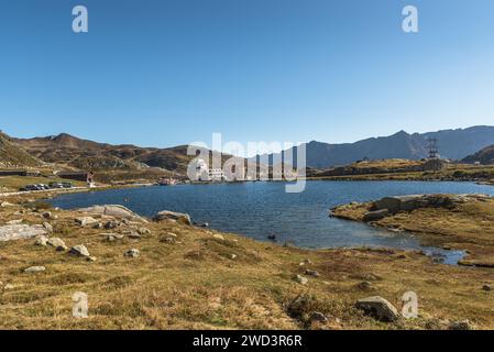 Haut plateau au sommet du col du Gothard avec lac Lago della Piazza et bâtiments historiques en arrière-plan, Canton du Tessin, Suisse Banque D'Images