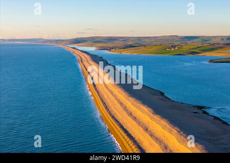 Weymouth, Dorset, Royaume-Uni. 18 janvier 2024. UK Météo. Vue aérienne vers l'ouest vers Abbotsbury le long de Chesil Beach et le lagon Fleet à Wyke Regis près de Weymouth sur la Dorset Jurassic Coast par un après-midi froid et ensoleillé. Crédit photo : Graham Hunt/Alamy Live News Banque D'Images