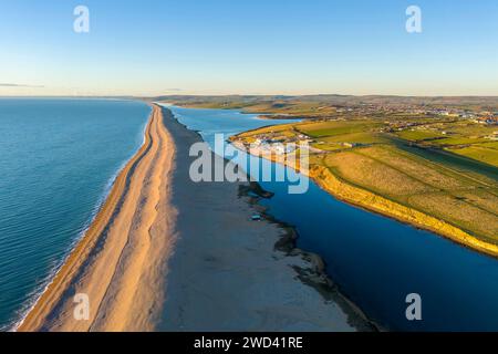 Weymouth, Dorset, Royaume-Uni. 18 janvier 2024. UK Météo. Vue aérienne vers l'ouest vers Abbotsbury le long de Chesil Beach et le lagon Fleet à Wyke Regis près de Weymouth sur la Dorset Jurassic Coast par un après-midi froid et ensoleillé. Crédit photo : Graham Hunt/Alamy Live News Banque D'Images