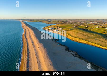 Weymouth, Dorset, Royaume-Uni. 18 janvier 2024. UK Météo. Vue aérienne vers l'ouest vers Abbotsbury le long de Chesil Beach et le lagon Fleet à Wyke Regis près de Weymouth sur la Dorset Jurassic Coast par un après-midi froid et ensoleillé. Crédit photo : Graham Hunt/Alamy Live News Banque D'Images