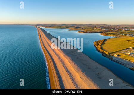 Weymouth, Dorset, Royaume-Uni. 18 janvier 2024. UK Météo. Vue aérienne vers l'ouest vers Abbotsbury le long de Chesil Beach et le lagon Fleet à Wyke Regis près de Weymouth sur la Dorset Jurassic Coast par un après-midi froid et ensoleillé. Crédit photo : Graham Hunt/Alamy Live News Banque D'Images