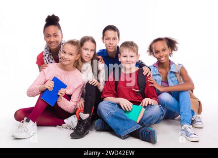 groupe de camarades de classe assis sur le sol isolé sur fond blanc Banque D'Images