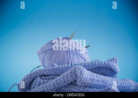 Kit de tricot à la main, fil bleu, aiguilles à tricoter et plus isolé sur un fond bleu. Banque D'Images