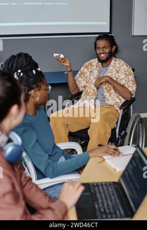 Homme avec handicap dans la tenue élégante donnant la présentation à ses collègues à la conférence d'affaires Banque D'Images