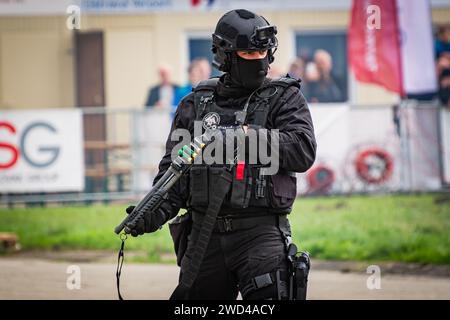 Homme avec fusil de chasse. Officier tactique du SWAT de la force frontalière tchèque debout dans un blindée complet tenant un fusil de chasse lors du spectacle aérien des Journées de l'OTAN. Banque D'Images