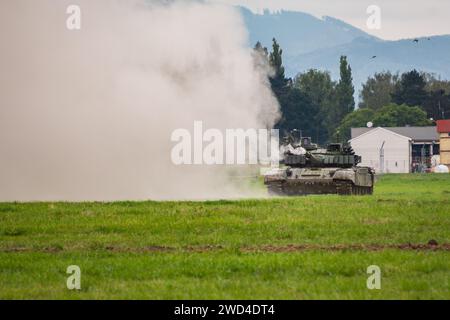 Char de combat T-72 (variante M4 - CZ) tirant son canon à tourelles principal sur un terrain vert pendant une répétition de jeu de guerre. Banque D'Images