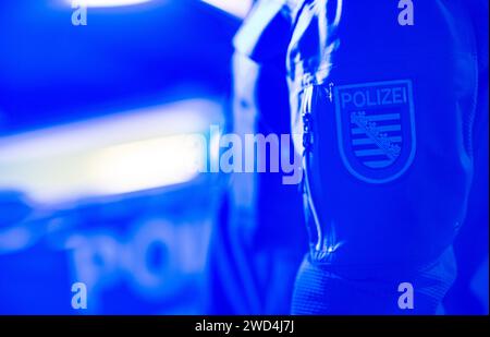 Dresde, Allemagne. 18 janvier 2024. Un policier se tient à côté d'une voiture de police. Crédit : Robert Michael/dpa/Alamy Live News Banque D'Images