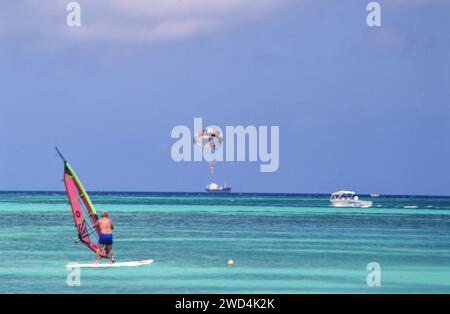 Planche à voile, planche à voile et parachute ascensionnel sont poplular au large de Palm Beach à Aruba ca. Milieu des années 1990 Veuillez créditer la photographe Joan Iaconetti. Banque D'Images