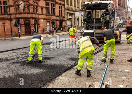 Travailler à la réparation de nids-de-poule dans le centre-ville de Glasgow en préparation de l'événement UCI Cycling. Banque D'Images