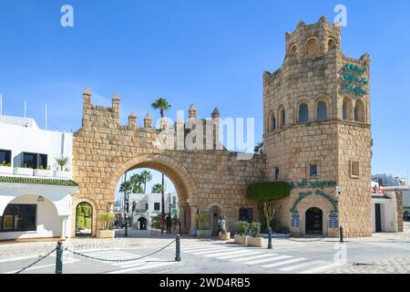 Port El Kantaoui, Sousse, Tunisie. Le portail en pierre et la tour décorent l'entrée de la rue commerçante et de la marina. Banque D'Images