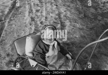 Une photo antique montre une petite fille caucasienne assise dans une poussette. Allemagne. Date inconnue, vers les années 1950 Banque D'Images