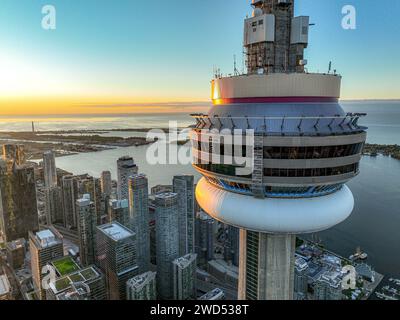 Une tour majestueuse domine un horizon de la ville au coucher du soleil, offrant une vue imprenable sur l'eau chatoyante Banque D'Images