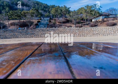 Dessus légèrement flou de table de pique-nique en bois avec sièges amphithéâtre et bâtiments dans le parc public en arrière-plan, Corée du Sud, Corée du Sud, Sud Banque D'Images