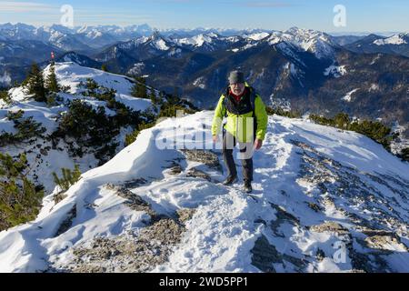 Randonneur escaladant le Wallberg, Zugspitze et Benediktenwand en arrière-plan, hiver, neige, Rottach-Egern, montagnes de Mangfall, Préalpes bavaroises, haute Banque D'Images