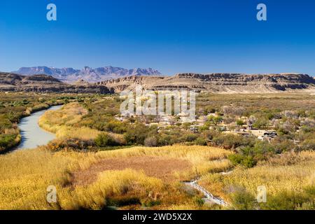 Vue sur un terrain de camping Rio Grande Village et la rivière Rio Grande et les montagnes Chisos ; parc national de Big Bend, Texas, États-Unis. Banque D'Images