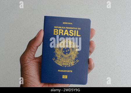 Vue rapprochée du passeport brésilien, avec sa couverture bleue et dorée, symbolisant la diversité et la richesse culturelle du Brésil. Banque D'Images