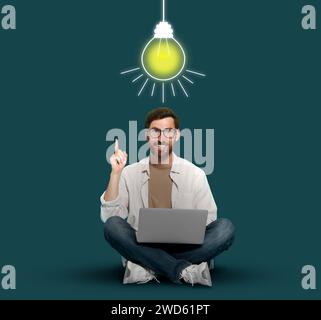 Génération d'idées. Homme avec ordinateur portable sur fond sarcelle. Illustration de la lumière de lampe incandescente au-dessus de lui Banque D'Images