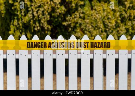 Signalisation d'avertissement concernant les risques de poussière d'amiante à l'extérieur d'une propriété à Motueka, région de Tasman, Aotearoa / Nouvelle-Zélande. Banque D'Images